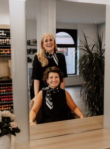 Das Bild zeigt Claudia und Nadine vor einem Spiegel sitzend